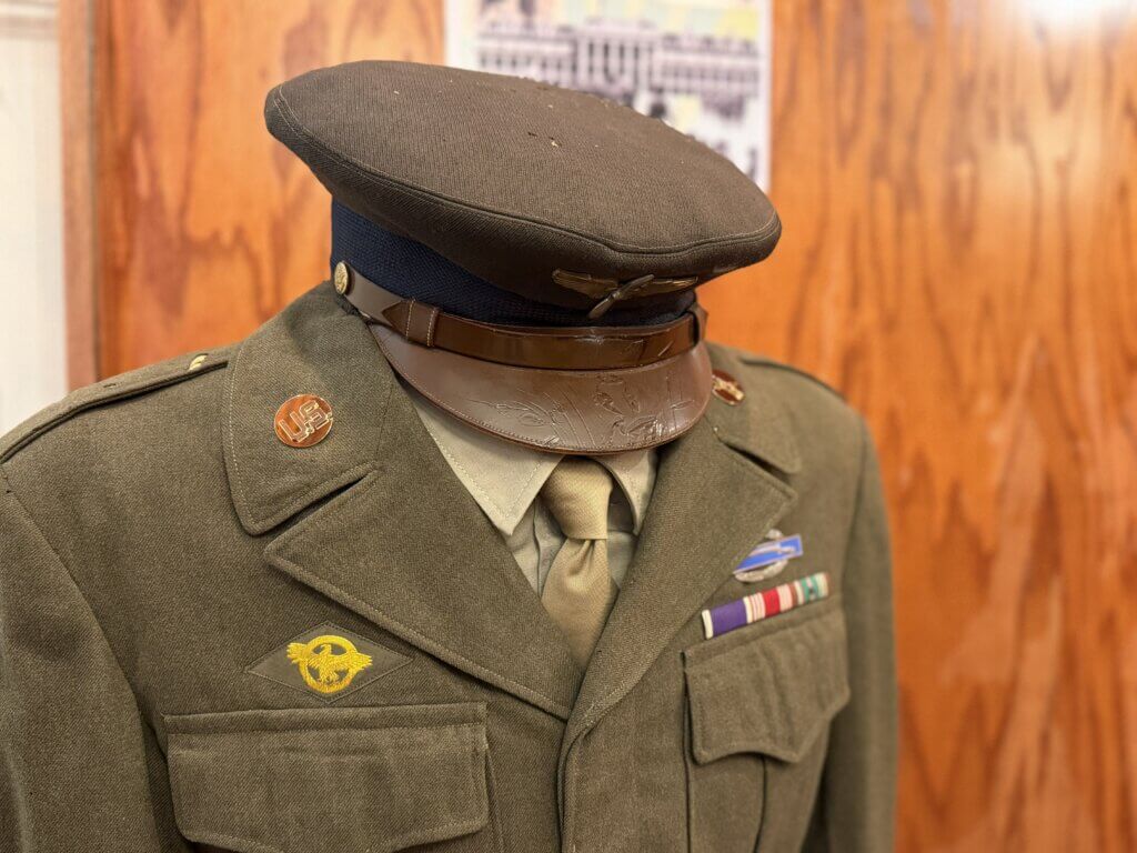 IMG_4670 - Experience Camden, South Carolina WWII-era US Army dress uniform on a mannequin with olive-green coat, dark hat, and service ribbons on the chest.