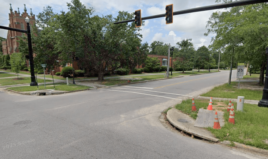 lyttleton and laurens Intersection with traffic lights and a crosswalk at a campus street; orange construction cones and a curb ramp on the right edge.