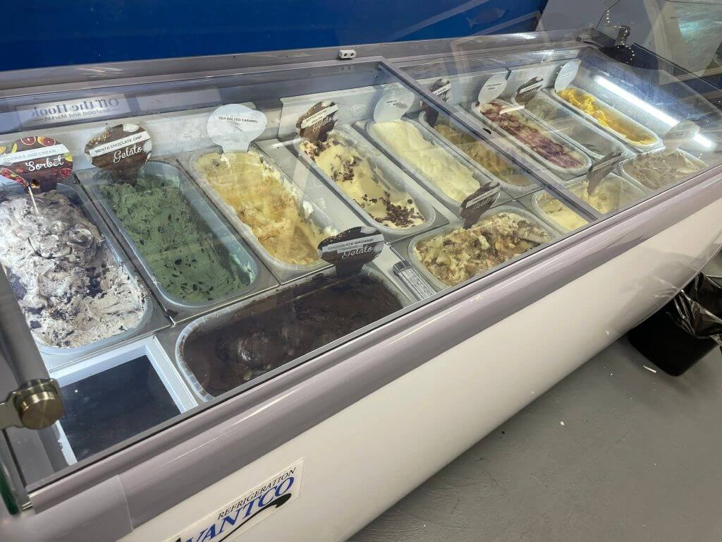 gelato oth1 - Experience Camden, South Carolina Glass-front gelato display with many flavored ice cream tubs in a shop