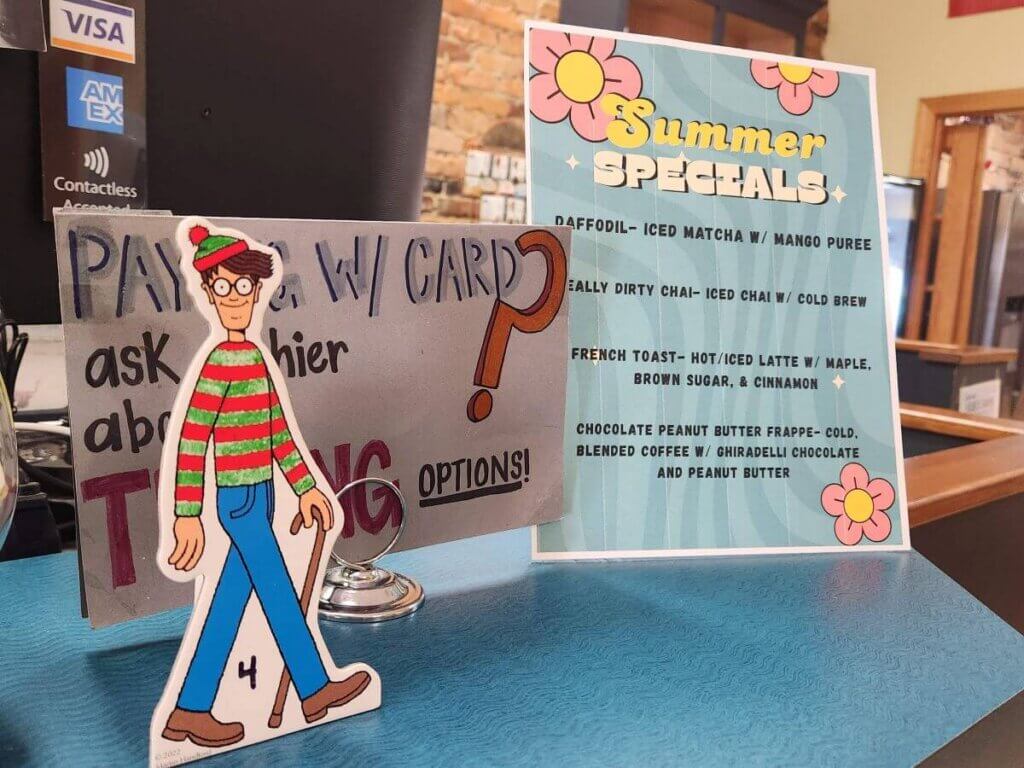 waldo2 - Experience Camden, South Carolina Cafe counter with a bright'Summer Specials' menu sign and a cartoon elf cutout in the foreground.